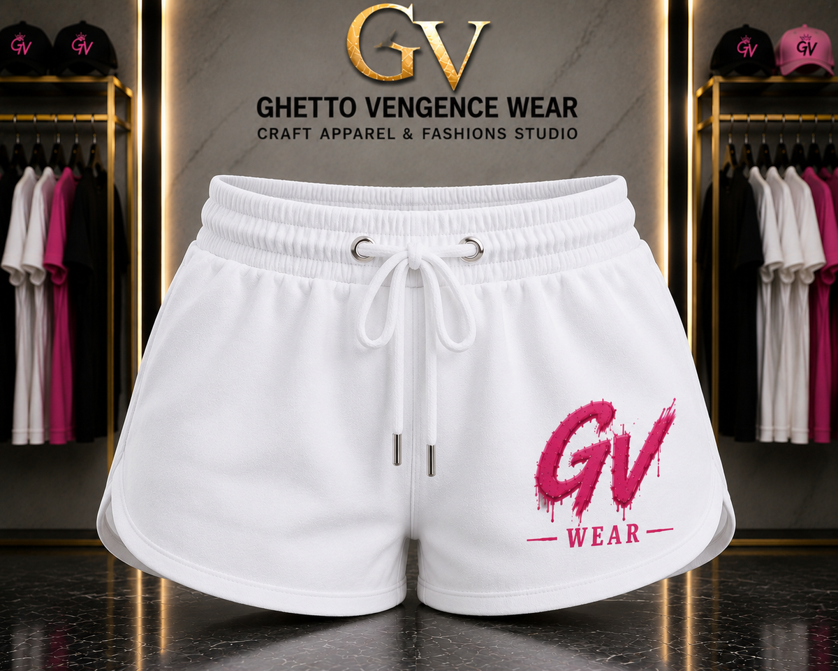 White drawstring shorts with a pink 'GV WEAR' logo on the left leg, displayed in a boutique setting with clothing racks and a branded wall sign behind them.